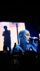 A stunning close-up of Justin Bieber performing his heartfelt ballad 'Ghost' live on stage. The crowd watches in awe as his emotional vocals fill the arena.